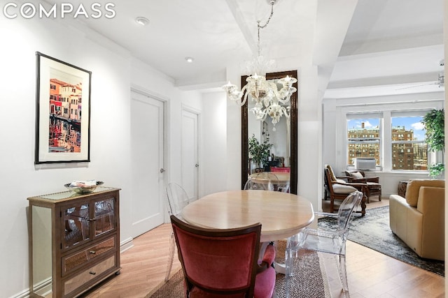 dining room with light hardwood / wood-style flooring and a notable chandelier