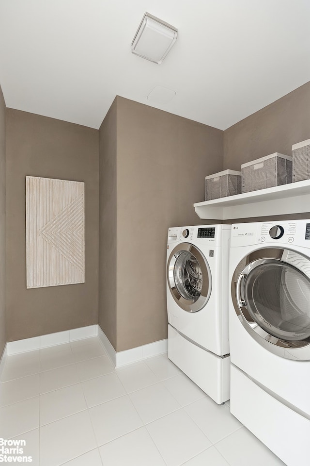 laundry area with baseboards, separate washer and dryer, light tile patterned flooring, and laundry area