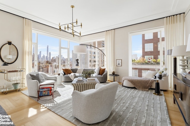 living area featuring a wealth of natural light, a view of city, an inviting chandelier, and wood finished floors