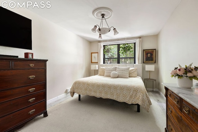 bedroom with a chandelier and light hardwood / wood-style floors