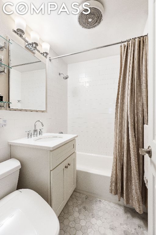 full bathroom featuring vanity, shower / bath combination with curtain, and toilet