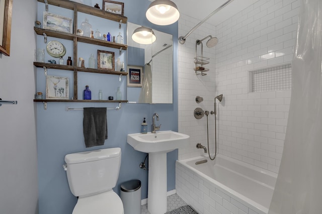 bathroom featuring tiled shower / bath combo, toilet, and tile patterned flooring
