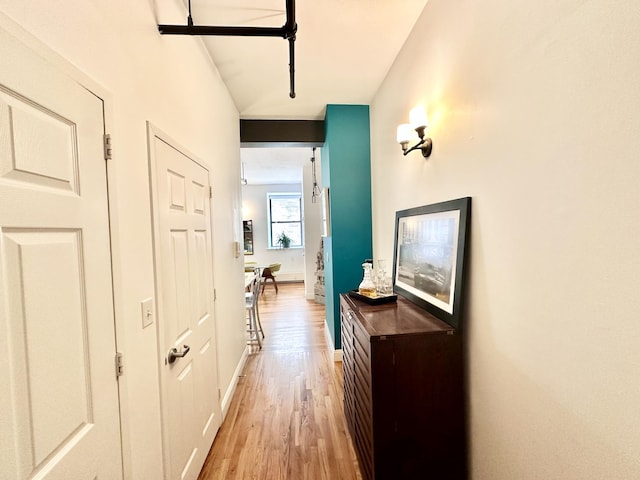 hall with light wood finished floors and baseboards