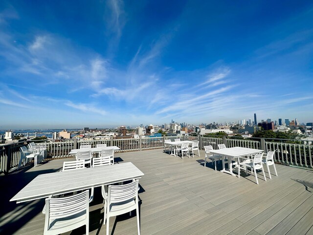 wooden terrace with a view of city and outdoor dining area