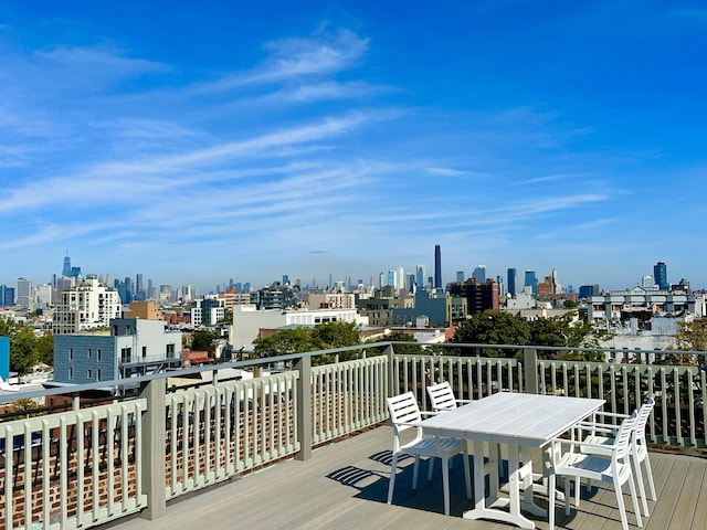 wooden deck featuring outdoor dining area and a skyline view