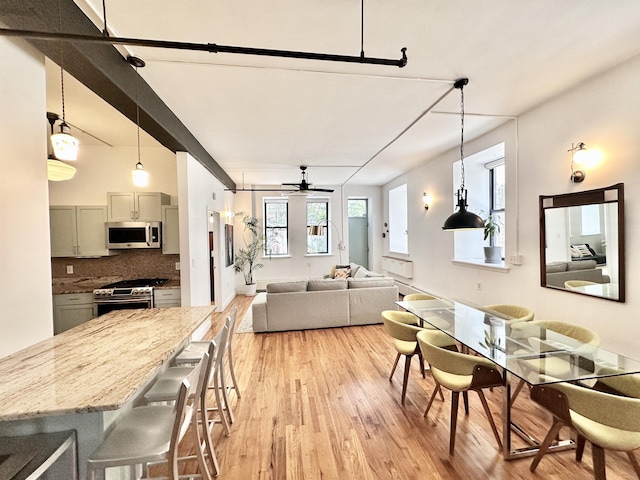 dining area with light wood-style flooring and ceiling fan