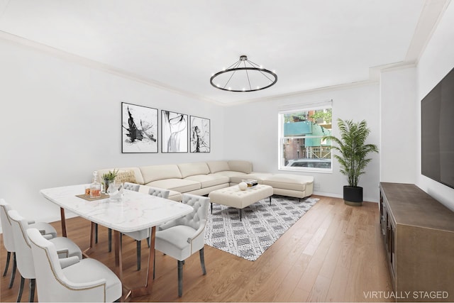 living area featuring ornamental molding, wood finished floors, and a notable chandelier