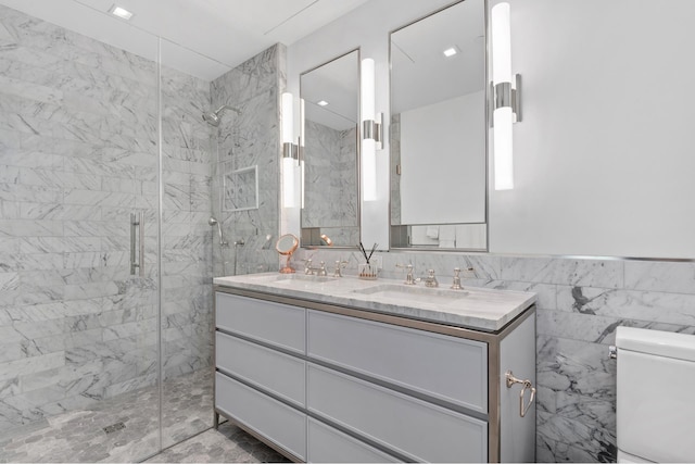 bathroom with tile walls, toilet, a stall shower, and a sink