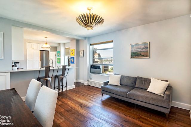 living area featuring a notable chandelier, cooling unit, baseboards, and dark wood-style flooring