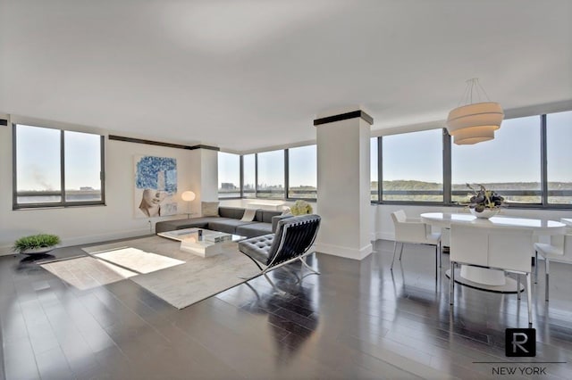 living area with dark wood-type flooring and baseboards