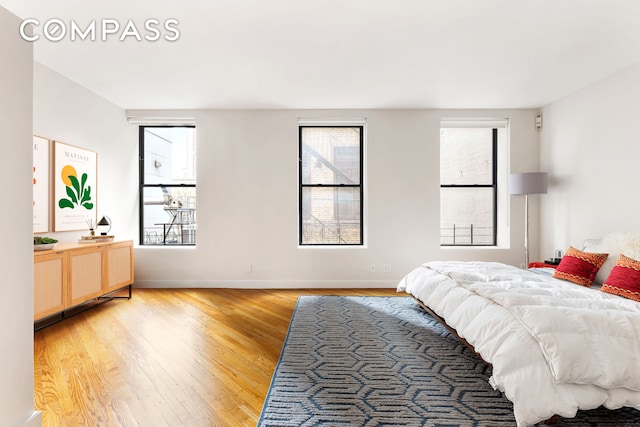 bedroom with light wood finished floors and baseboards