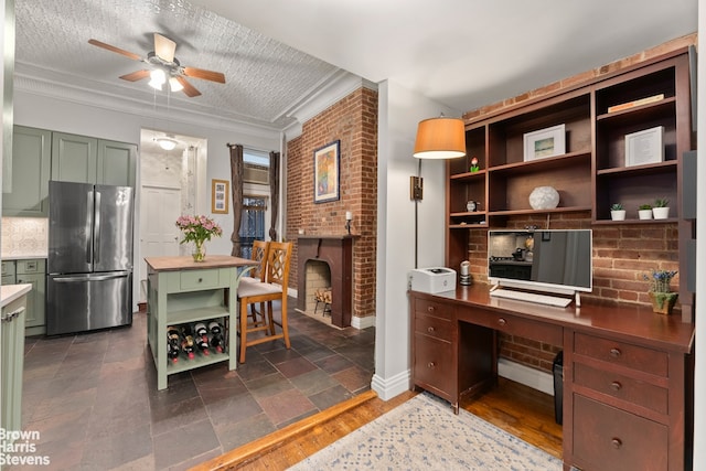 office area with a brick fireplace, ornamental molding, ceiling fan, and brick wall