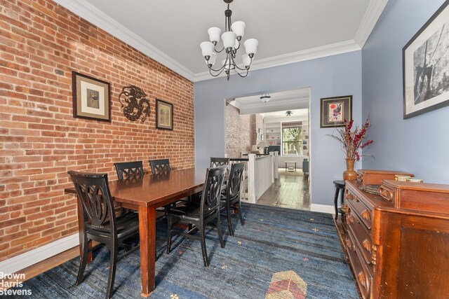 dining area featuring crown molding, brick wall, dark wood-type flooring, and an inviting chandelier