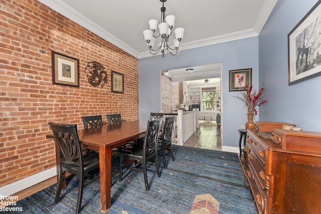 dining area featuring baseboards, dark wood finished floors, brick wall, crown molding, and a chandelier