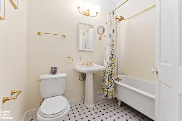 full bathroom featuring toilet, baseboards, and shower / bath combo