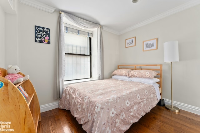 bedroom with wood finished floors, baseboards, and ornamental molding