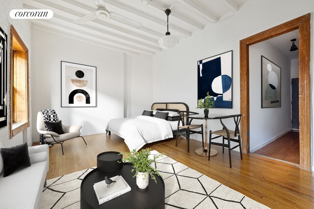 bedroom with beamed ceiling and light hardwood / wood-style floors