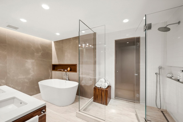 bathroom with tile walls, a freestanding tub, and a shower stall