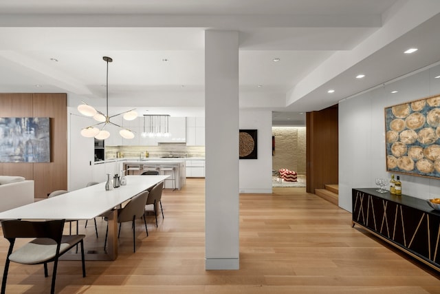 dining area featuring light wood-style floors, an inviting chandelier, and recessed lighting