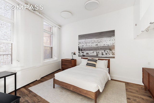 bedroom featuring wood finished floors and baseboards