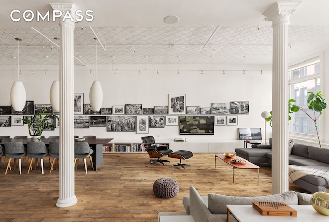 living room featuring wood-type flooring and decorative columns