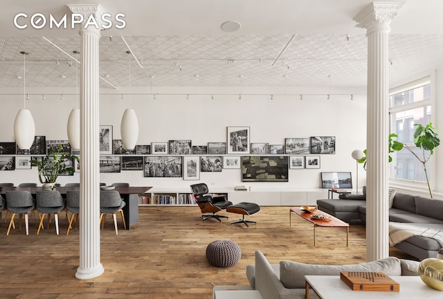 interior space featuring wood finished floors and decorative columns