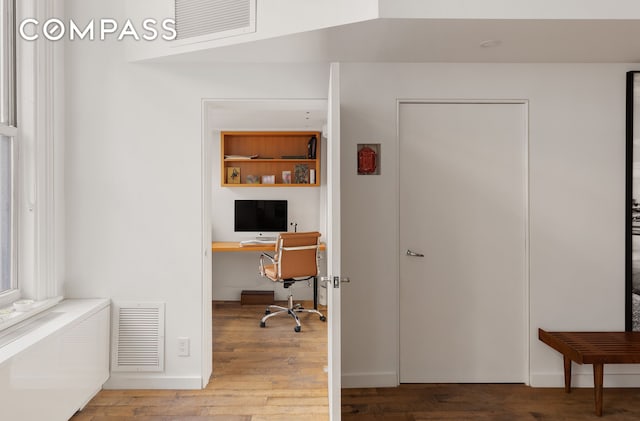 office area featuring wood finished floors, visible vents, and baseboards