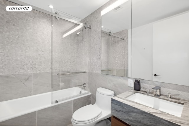 full bathroom with toilet, vanity, and shower / bath combination with glass door