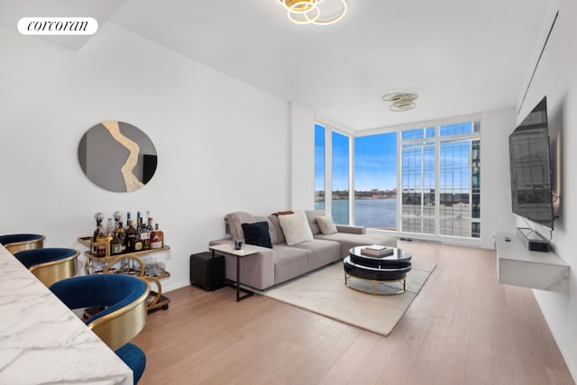 living room with light hardwood / wood-style flooring, bar, and expansive windows