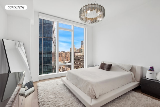 bedroom featuring hardwood / wood-style flooring, a chandelier, and floor to ceiling windows