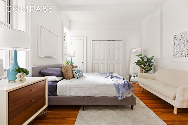 bedroom featuring dark wood-style floors and a high ceiling