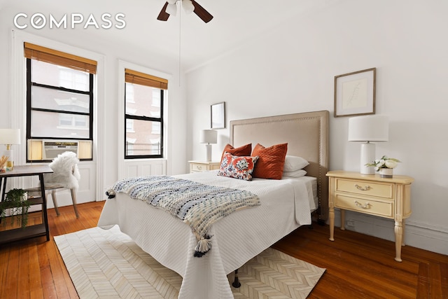 bedroom with cooling unit, wood-type flooring, and ceiling fan