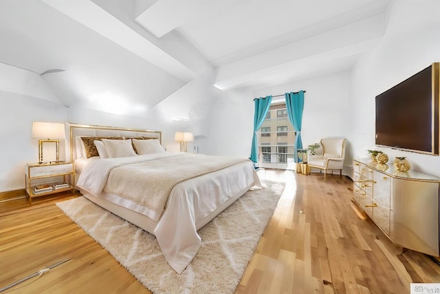 bedroom with vaulted ceiling and light wood-type flooring