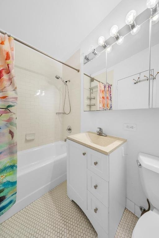 full bathroom with vanity, shower / bath combo with shower curtain, and toilet