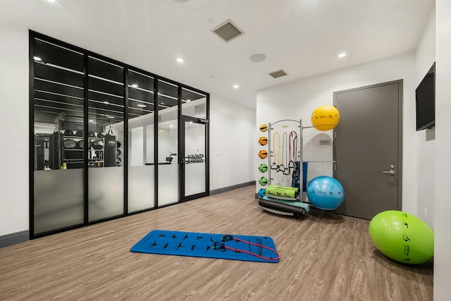 workout room with visible vents, recessed lighting, baseboards, and wood finished floors