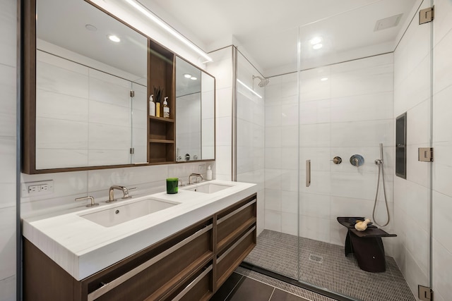 full bathroom featuring a sink, a stall shower, and double vanity