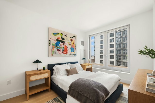 bedroom with baseboards and light wood-type flooring