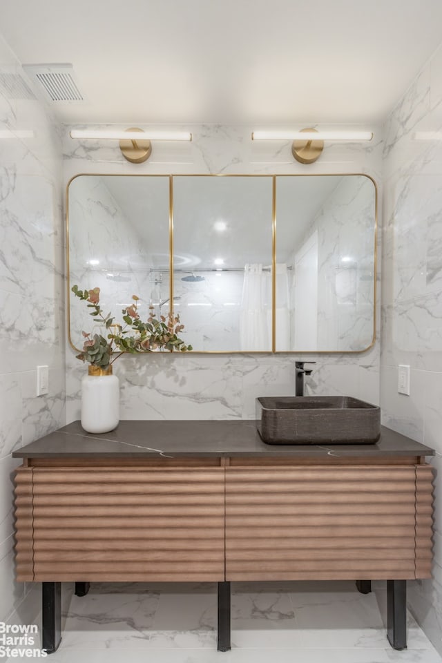 bathroom with marble finish floor, stone wall, visible vents, and tile walls