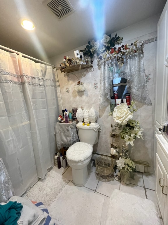 bathroom featuring tile walls, tile patterned flooring, curtained shower, and toilet