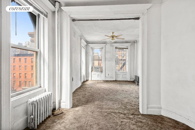 hall featuring carpet flooring and radiator