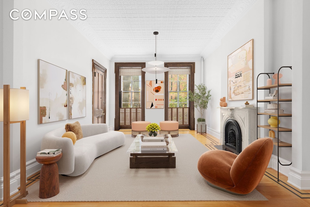 living area featuring a fireplace, baseboards, and wood finished floors