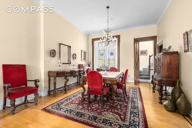 dining space with hardwood / wood-style flooring, an inviting chandelier, and a textured ceiling