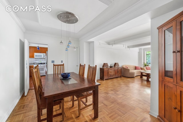 dining area featuring a tray ceiling and ornamental molding