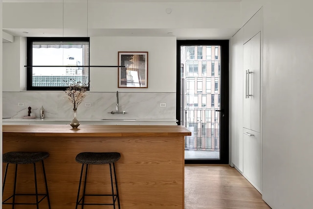 9 Chapel St Unit 8A, New York City, NY 11201 - bar featuring light wood finished floors, wet bar, floor to ceiling windows, and decorative backsplash