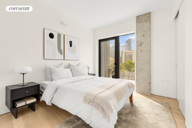 bedroom with access to exterior and light wood-type flooring