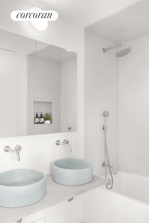 bathroom featuring vanity and  shower combination