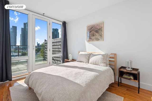 bedroom with wood-type flooring and access to exterior