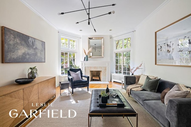 living room featuring a fireplace, radiator heating unit, ornamental molding, and a healthy amount of sunlight