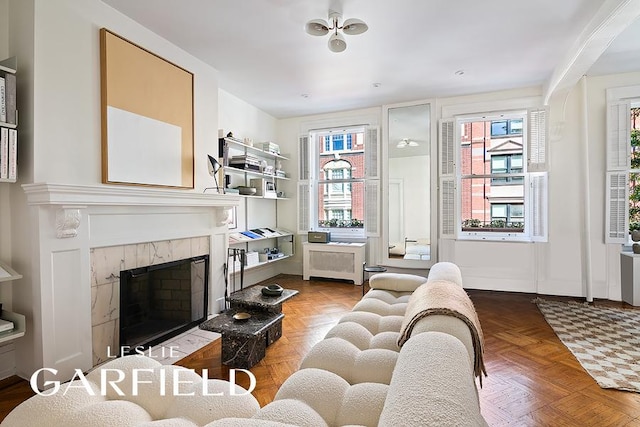 living room with a premium fireplace and parquet flooring