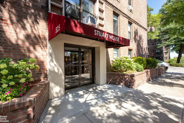 view of exterior entry featuring brick siding